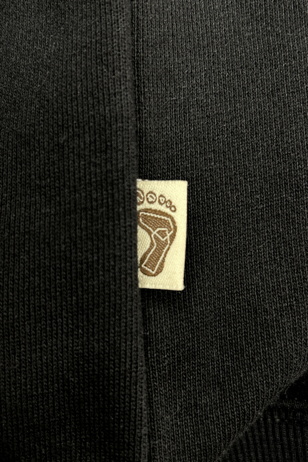 Tag-up of 16 Sixteen embroidered logo on TRIBE WEAR zip-up hoodie