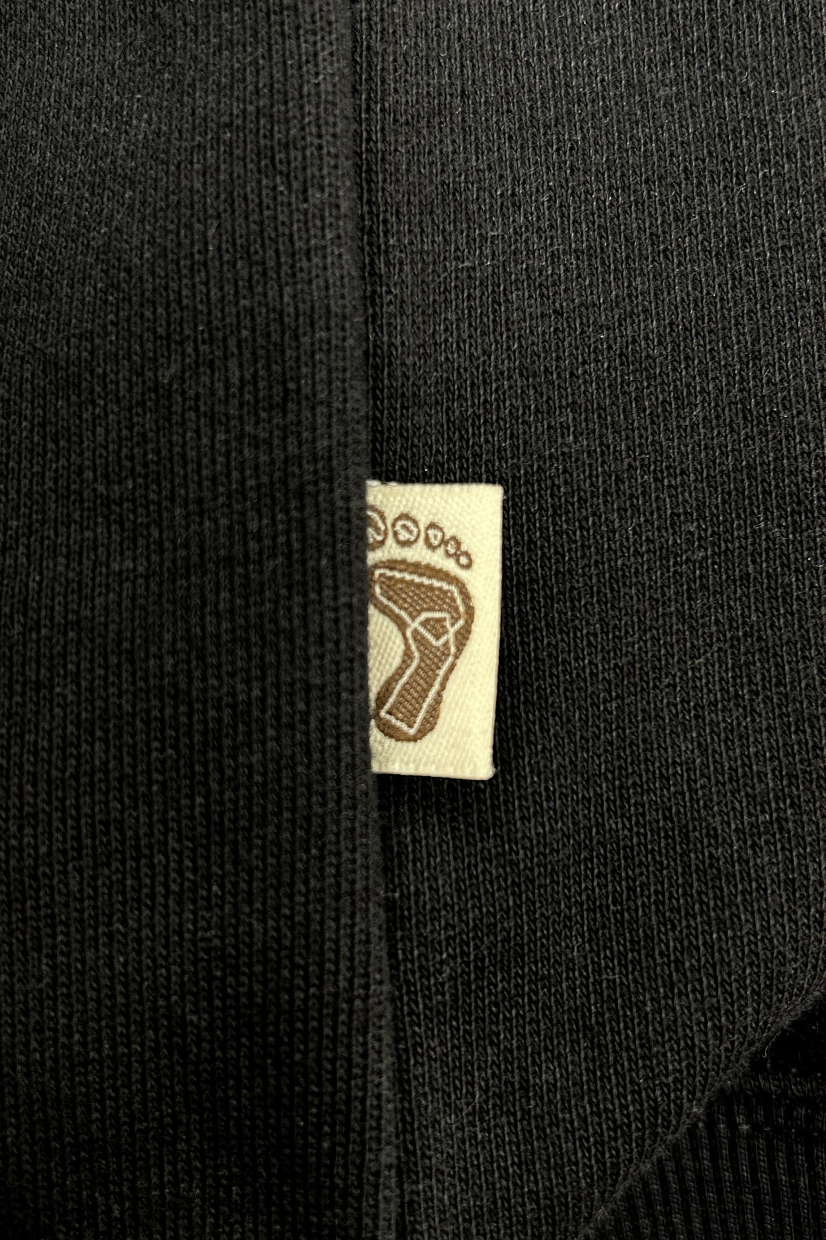 Tag-up of 16 Sixteen embroidered logo on TRIBE WEAR zip-up hoodie